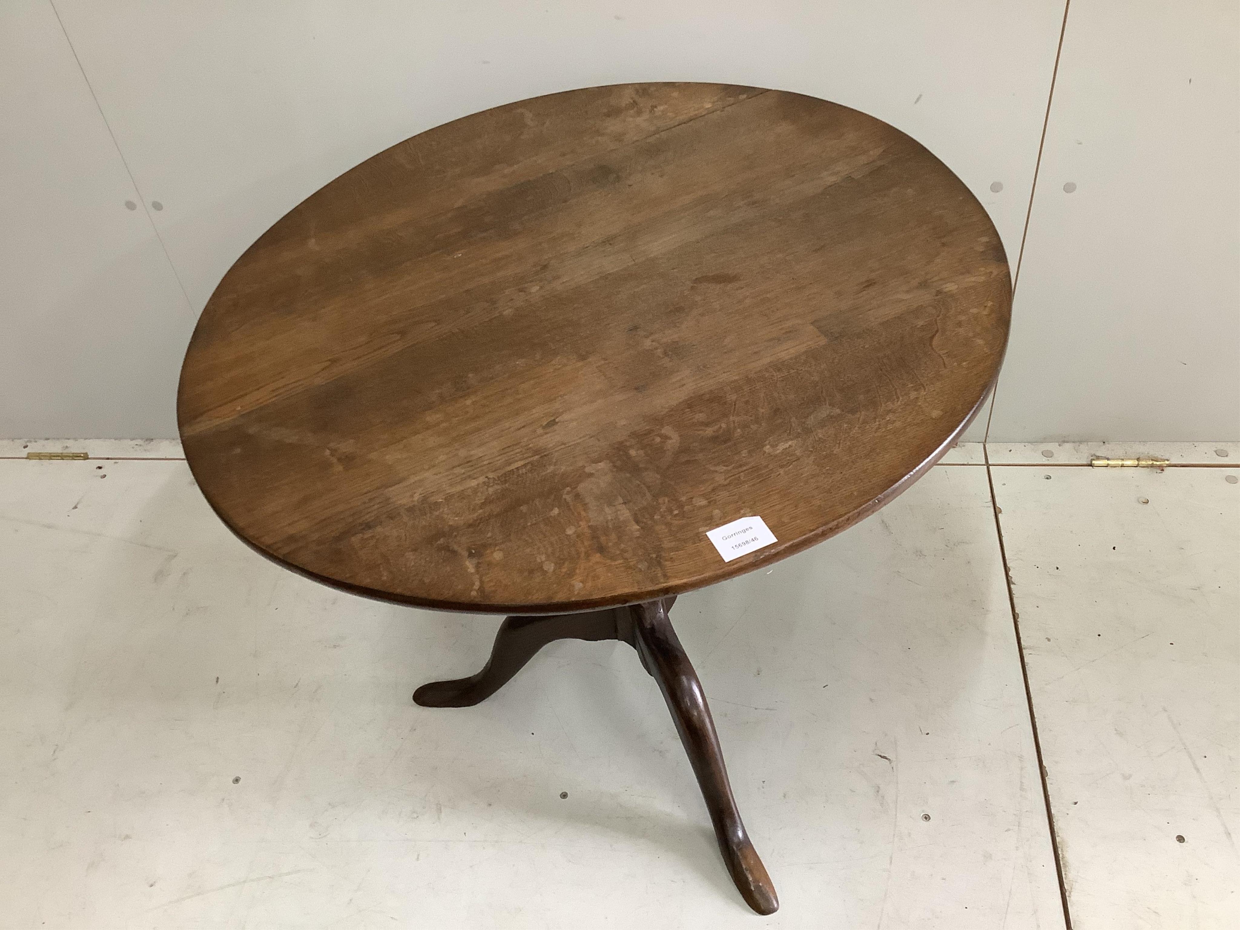 A George III circular oak tilt top tripod table, diameter 76cm. Condition - restorations